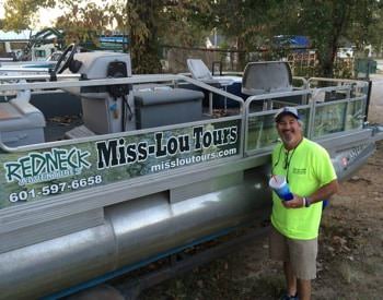 Man standing in front of pontoon boat with Miss-Lou Tours sign